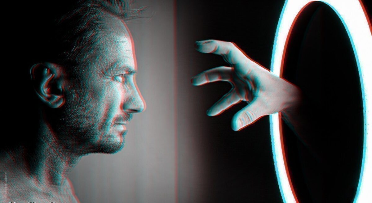 Foto: Zustand während einer Schlafparalyse: Ein Gesicht schaut in eine runden Spiegel mit grell leuchtendem Rahmen. Die Spiegelfläche ist schwarz, eine Hand greift heraus Richtung Gesicht.